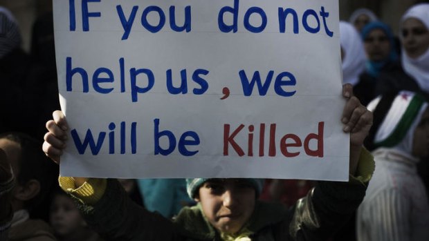 A boy holds up a sign during a demonstration against the regime in the Syrian village of al-Qsair, about 25 kilometres south-west of the flashpoint city of Homs.