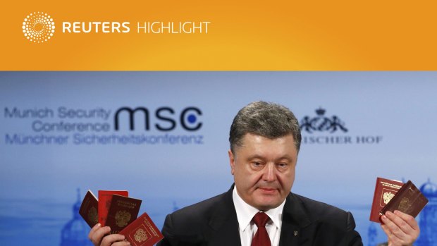 Ukraine's President Petro Poroshenko holds Russian passports to prove the presence of Russian troops in Ukraine as he addresses the 51st Munich Security Conference.