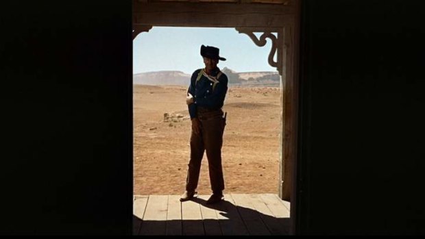 Destiny at the door: John Wayne as Ethan in John Ford's legendary film of <i>The Searchers</i>.