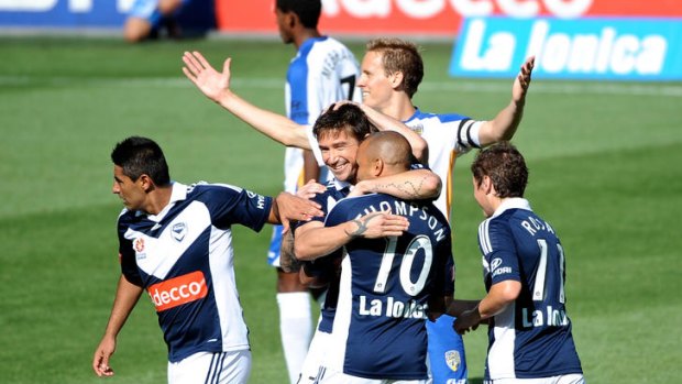 Melbourne Victory players celebrate with Harry Kewell after he scored from a penalty.
