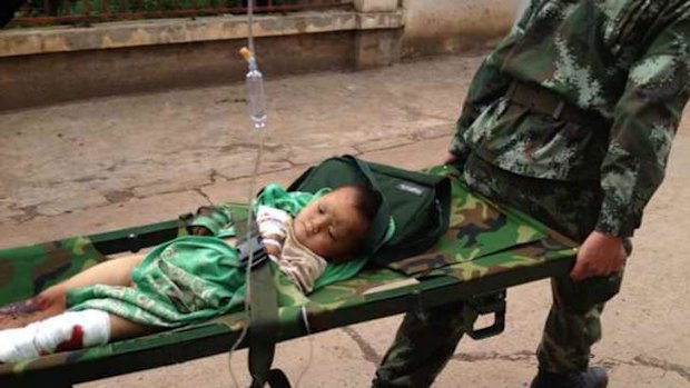 Rescuers in Zhaotong carry an injured child after the earthquake.