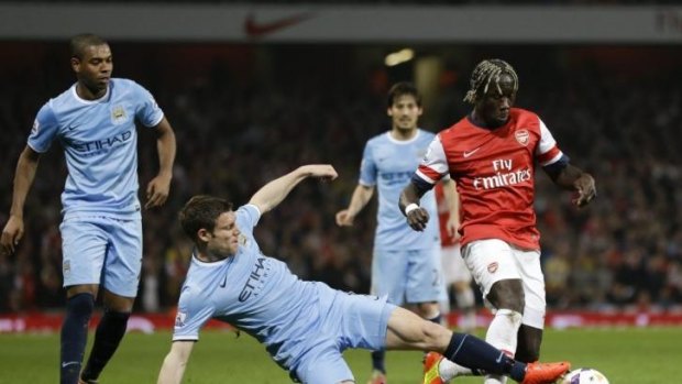 Manchester City's James Milner gets a foot on the ball ahead of Arsenal's Bacary Sagna  at Emirates Stadium.