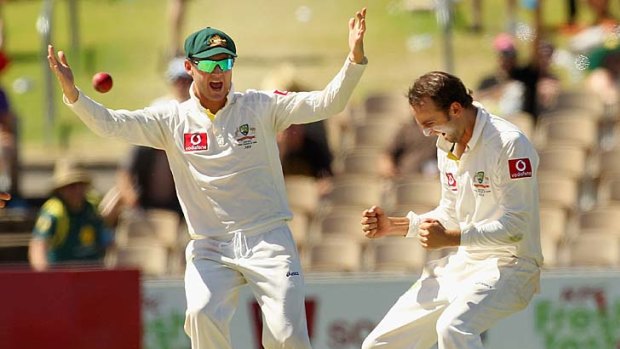Chuffed: Nathan Lyon (right) celebrates with Michael Clarke after taking the wicket of Sachin Tendulkar yesterday in Adelaide.
