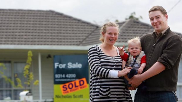 Ben Hoban, partner Frith and their one-year-old daughter Archer in front of their new house.