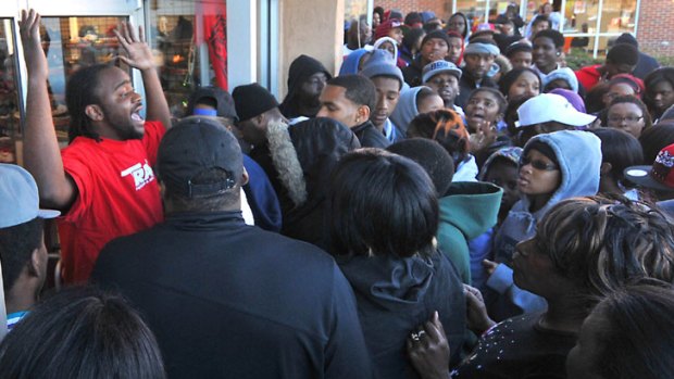 A store employee pleads with a crowd waiting to buy Nike's newly released Air Jordan 11 Retro Concords to "back up" outside the Trax shoe store Charlotte, North Carolina.