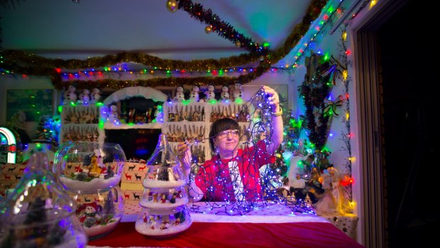 Tangled up in blue: Monica Azzopardi sets up lights for her Christmas display.