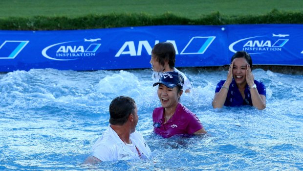 Lydia Ko with her caddie Jason Hamilton, her sister Sura Ko and her mother Tina Hyon after the leap into Poppie's Pond at the 18th green after her victory in the final round of the 2016 ANA Inspiration at the Mission Hills Country Club in Rancho Mirage, California. 