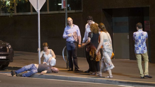 A man lies passed out on a Sydney street.