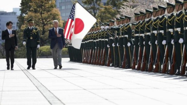 Japan's Defence Minister Itsunori Onodera (left) and US Secretary of Defence Chuck Hagel (right) review honour guards at the Japanese Ministry of Defence in Tokyo.