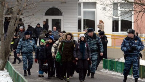Moscow school: Students are escorted out of the building after an armed man kills two.
