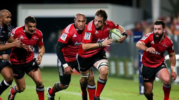 Ferocious: the Crusaders’ returning talisman, Richie McCaw, makes a bust during Saturday’s big win over the Sharks which booked the Kiwis a spot in the grand final.