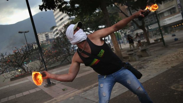 A protester throws a molotov cocktail at Venezuelan security forces during an anti-government demonstration.