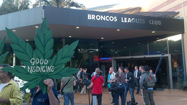 Members of the media and a few protesters await the arrival of Julia Gillard and Tony Abbott outside the Broncos Leagues Club in Red Hill this evening.