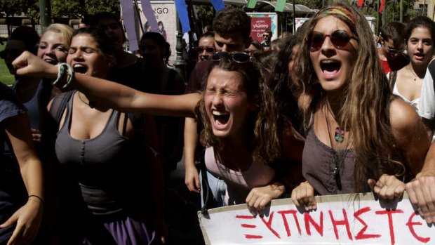 Student protesters hold banners and shout during a demonstration against austerity and job cuts in Athens, Greece.