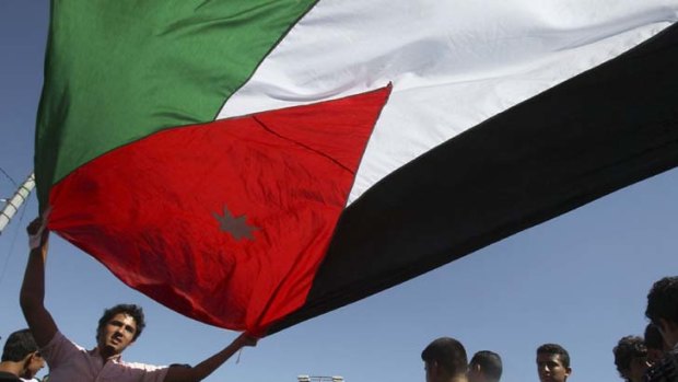 A Jordanian waves the country's national flag during celebrations of the 12th anniversary of King Abdullah's accession to the throne. The Jordanian monarch has become the first Middle Eastern leader to voluntary hand over power since the start of the "Arab Spring".