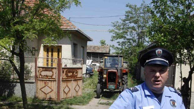 A Serbian police officer guards the Mladic family home, where Europe's most wanted war criminal was captured.