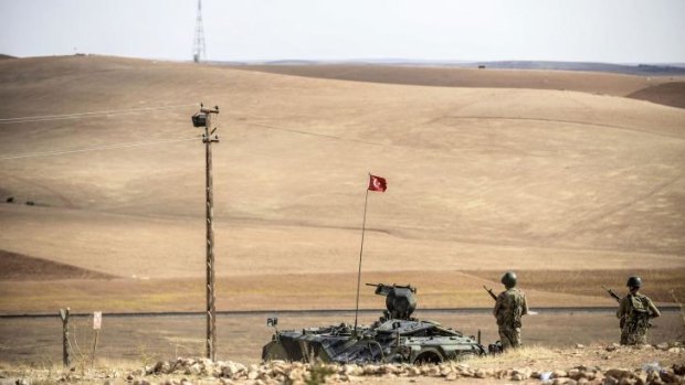 Turkish soldiers stand on a hill, facing IS fighters' position 10 kilometres west of the Syrian border town of Kobane.