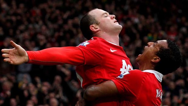 Wayne Rooney of Manchester United celebrates with teammate Nani (right) after he scored a goal.