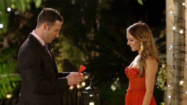Sasha whipping up a napkin rose for Sam Frost.