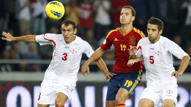 Narrow win ... Spain's Roberto Soldado struggles for the ball with Georgia's Dato Kvirkvelia and Aleksander Amisulashvili.