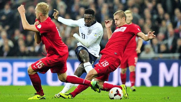 England's striker Danny Welbeck (centre) takes a shot as Poland's defenders Kamil Glik (left) and Piotr Celeban (right) try to thwart him during the World Cup qualifying match at Wembley Stadium on Tuesday.