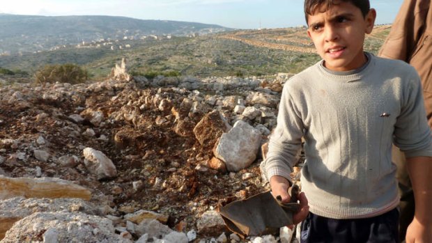 Lopsided conflict ... a Syrian boy next to a crater where a Scud missile landed between Damascus and Homs on Thursday.