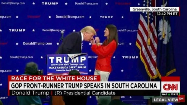 Donald Trump allows an unidentified audience member at his South Carolina press conference to inspect his hair.