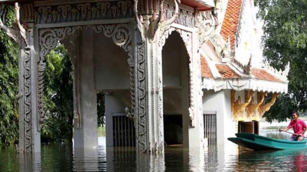 A man navigates the local temple by boat as flood waters rise in Thailand's Lopburi province, about 150 km north of Bangkok.
