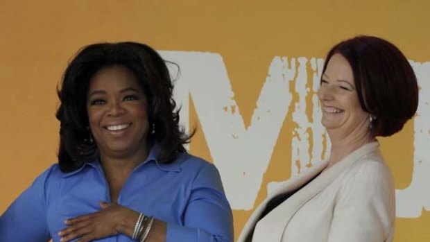 Women on top ... Oprah Winfrey and Julia Gillard share a laugh in front of screaming fans in Melbourne.