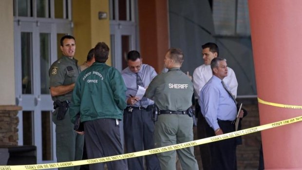 Pasco County Sheriff Chris Nocco (left) speaks with investigators outside the Cobb Grove 16 movie theater in Wesley Chapel, Florida. 