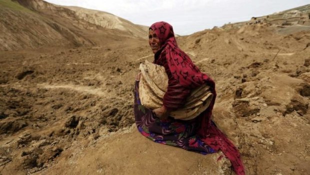 An Afghan woman cries after losing her family in the landslide.
