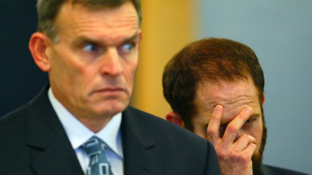 Israeli Uriel Zoshe Kelman (right) covers his face as he and compatriot Eli Cara sentenced at Auckland's High Court in 2004.