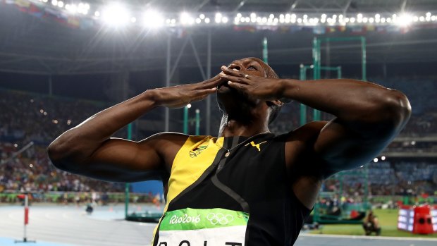 A kiss to the crowd: Usain Bolt celebrates his victory.