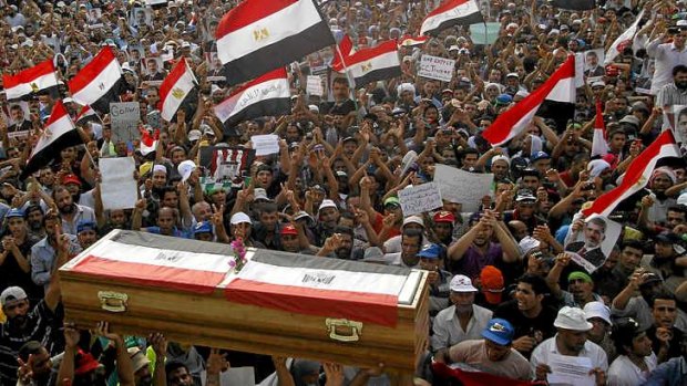 Egyptian supporters of ousted president Mursi conduct a mock funeral for those killed.