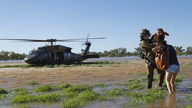 Battling the elements: An Australian soldier assists flood victims.