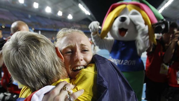 When Hannan met Sally: World champion Sally Pearson (right) is embraced by coach Sharon Hannan after the hurdler's gold-medal win.