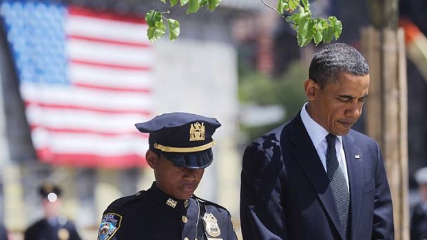 UIS President Barack Obama and New York police officer Stephanie Moses bow their heads at a wreath laying ceremony at Ground Zero.