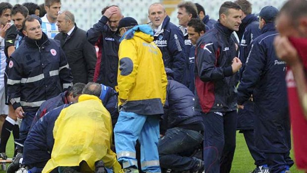 Dead at 25 ... medics assist Livorno's Piermario Morosini, as he lies on the turf.