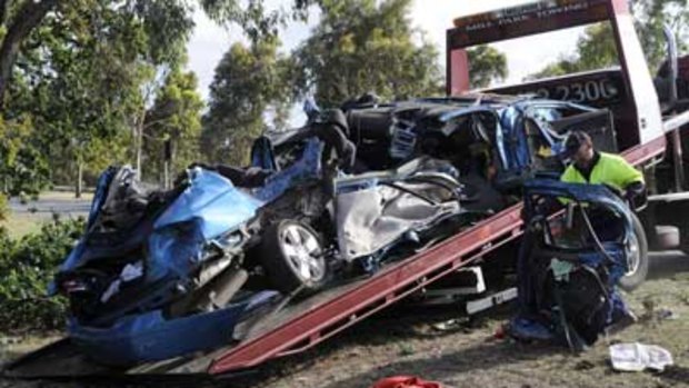 The remains of the car in which five young men died overnight is loaded onto the back of a truck. PHOTO: Pat Scala