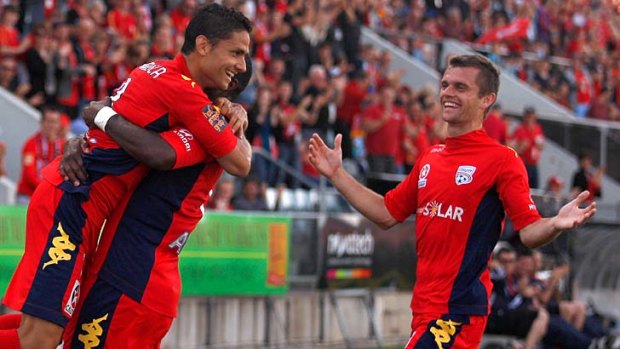 Jubilant: Adelaide's Marcelo Carrusca (left) celebrates his second goal against Wellington with Bruce Djite and Cameron Watson.