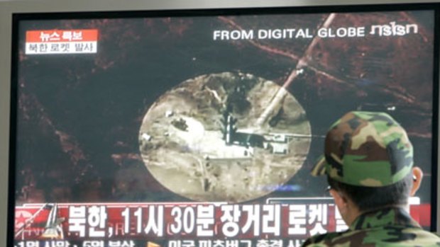 A South Korean Army soldier in Seoul watches a TV news report of a rocket launched by North Korea.
