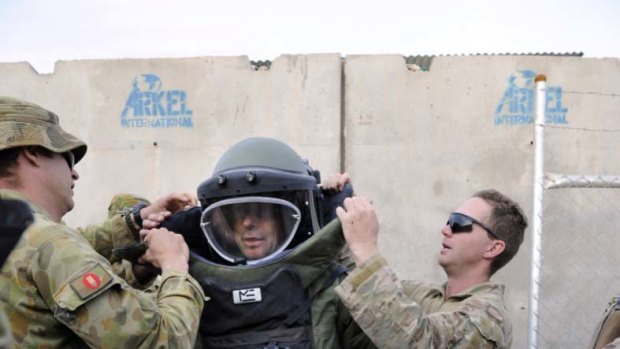 Hurt Locker style ... officers from the explosive ordinance disposal and weapons intelligence teams kit out Tony Abbott in a bomb disposal suit at the multi-national base at Tarin Kowt, Afghanistan.