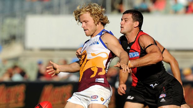Brisbane's Daniel Rich is hassled by Essendon's Brent Stanton during an NAB Cup Clash.