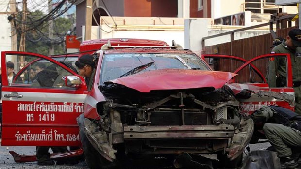 Bangkok blasts... police inspect a taxi damaged in one of the explosions.