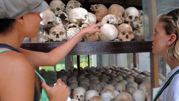 Tourists look at skulls displayed at the Choeung Ek Killing Fields Memorial near Phnom Penh.