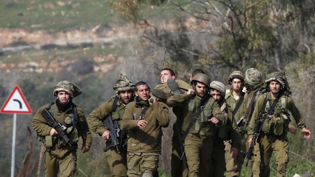 Israeli soldiers carry their injured comrade after an anti-tank missile hit an army vehicle in an occupied area on the border with Lebanon.