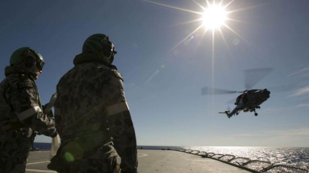 A helicopter leaves the flight deck of HMAS Success as it searches for the missing plane. 