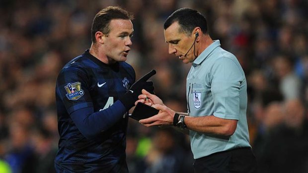 Wayne Rooney makes a point to referee Neil Swarbrick after being booked.