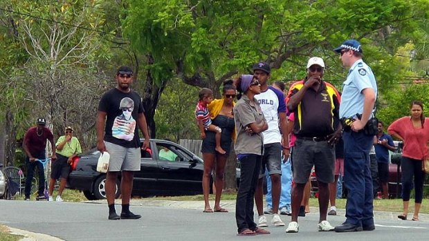 Police speak with young indigenous people and an Aboriginal elder in Douglas Street.