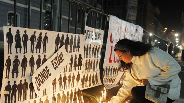 Devastating ... a relative places candles in remembrance of those who were tortured on board Esmeralda, the ship used as a detention and torture centre during the September 1973 military coup in Chile.